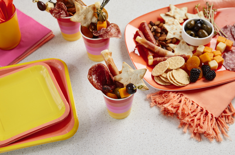 As festas pop vermelho, rosa e amarelo têm uma fatia de carne, queijo quadrado, bolachas e como uma xícara de charcutley completa.