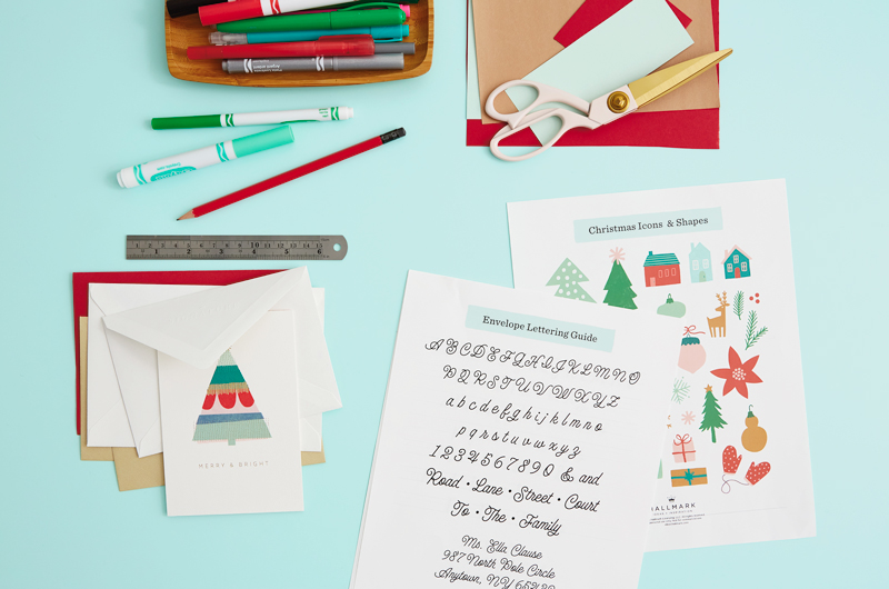 Os materiais necessários para a carta do envelope de Natal são cartões de férias e envelopes, governantes, lápis e marcadores, tesouras, papel de desenho e guia de envelopes de Natal gratuitos.