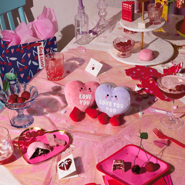 Um par de corações de conversas de veludo com ímãs colocados no centro da mesa decorados para os namorados.