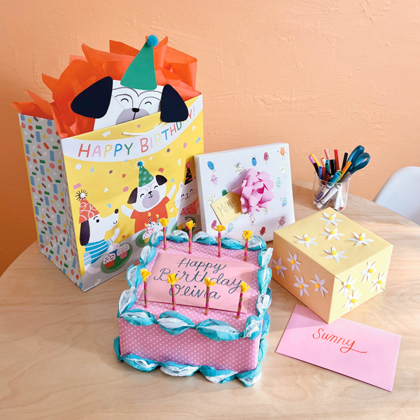 Diversos presentes embrulhados em papel de embrulho e sacolas de presentes são expostos de forma divertida e lúdica para as crianças.