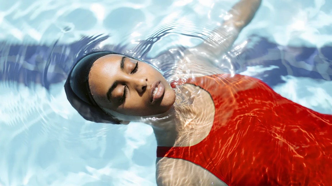 Uma mulher relaxando flutuando em uma piscina